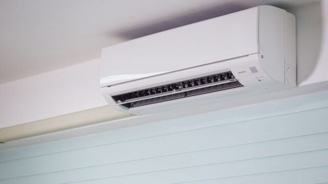 Close-up of a wall-mounted air conditioner indoors, showcasing sleek design for modern cooling solutions.