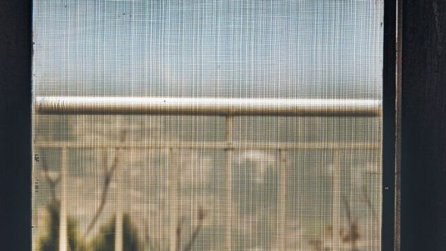 明るい室内の窓と網戸、すき間対策をしている様子