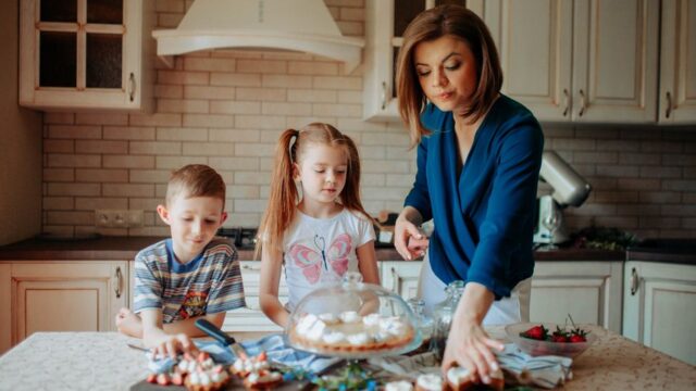 親子でクリスマスケーキにいちごを飾り付けている様子