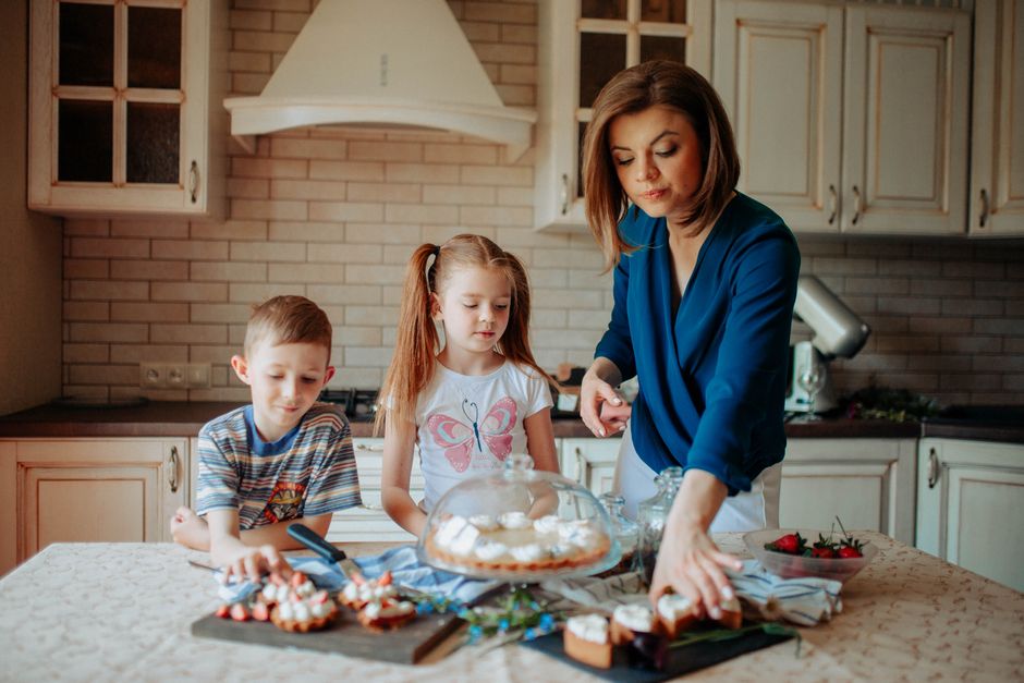 親子でクリスマスケーキにいちごを飾り付けている様子